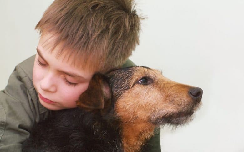 A child hugging his dog