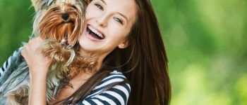 Beautiful young lady carrying her little dog
