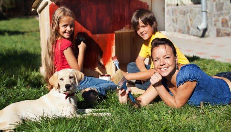 Happy family painting the doghouse together