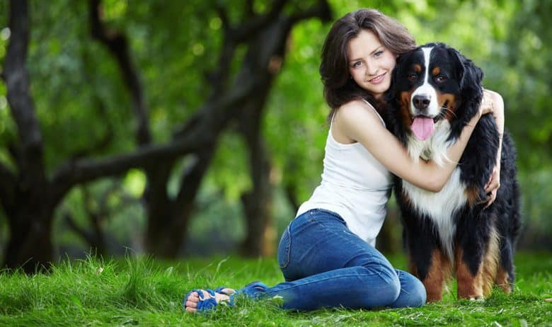 Young girl hugging her dog in the park