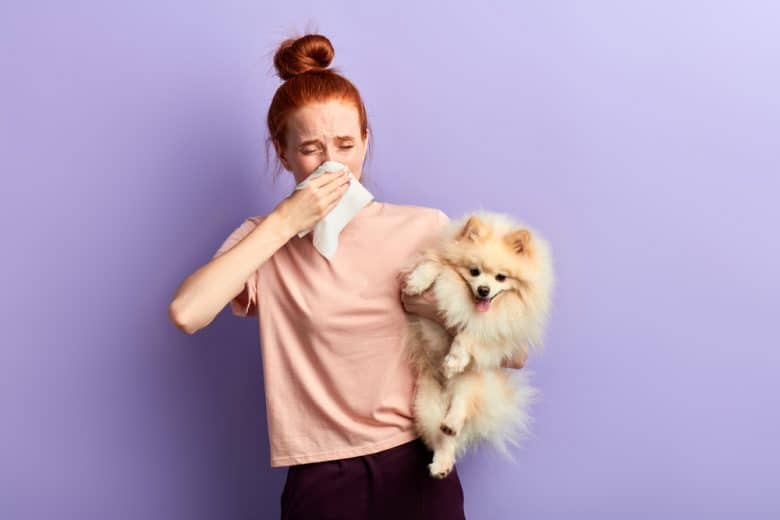 a sick red hair woman holding a Pomeranian dog