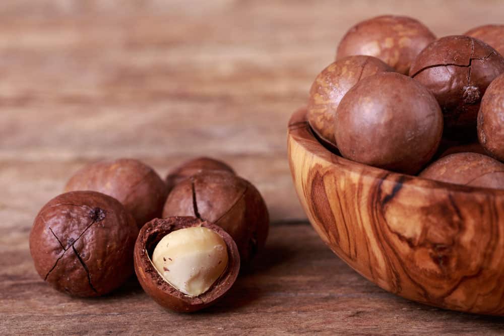 Macadamia nuts seed on wooden bowl